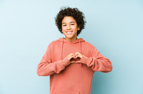 African american little boy isolated smiling and showing a heart shape with hands.