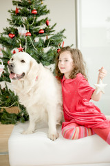 Happy child with golden retriever dog enjoying Christmas atmosphere