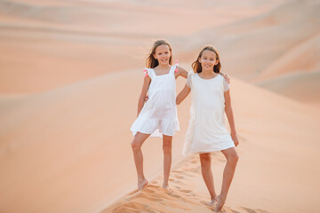 Girls among dunes in Rub al-Khali desert in United Arab Emirates