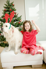 Happy child with golden retriever dog enjoying Christmas atmosphere