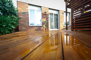 Backyard wooden deck floor boards with fresh brown stain