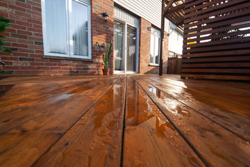Backyard wooden deck floor boards with fresh brown stain - 328586356