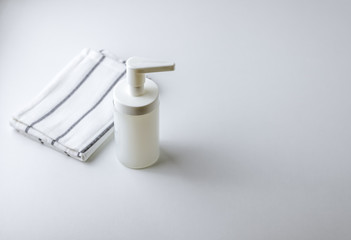 Cream soap in a transparent white soap dish with a towel on a white background with copy space
