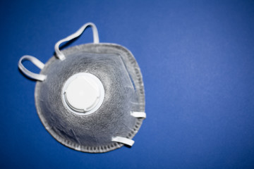 Close-up of flu protection mask on background of phantom blue color.