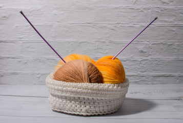 a ball of woolen thread in a white basket. Knitting and needlework.