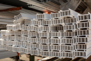 PVC plastic elements in workshop for door and window profile production line. PVC profile.