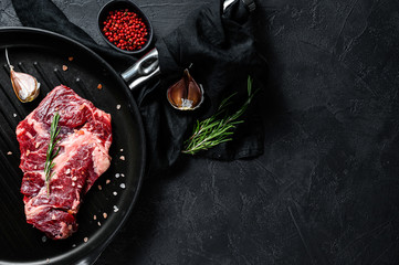 Marbled beef steak in a frying pan. Organic farm meat. Black background. Space for text