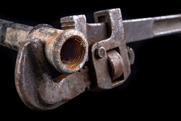 Old dirty pipe and hydraulic wrench. Accessories and tools for a plumber.