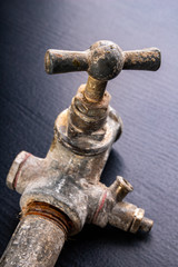 Old dirty metal water tap. Accessories and tools for a plumber.