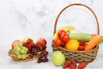 Fruits and vegetables in baskets on a concrete table. The concept of detox diet and weight loss,...
