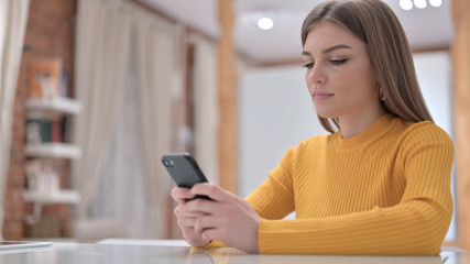 Fototapeta na wymiar Cheerful Creative Young Woman using Smartphone