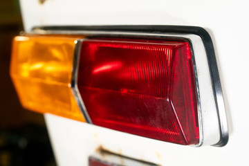 rear lantern or headlight of an old car with a white body