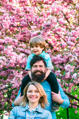 Fototapeta premium Portrait of Happy family outdoors. Mother, father and son. Young happy family of three having fun together outdoor.