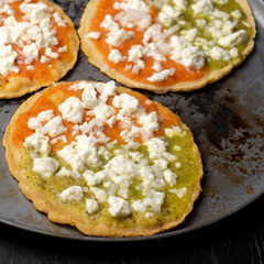 Mexican memela with green and red sauce on dark background