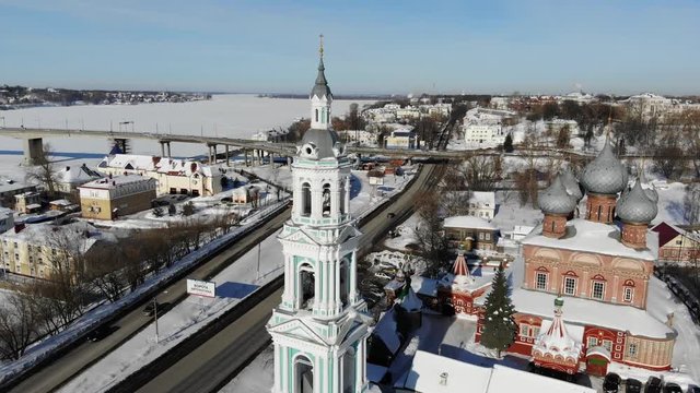 Slow cinematic flight by the Russian Church ("Church of the Resurrection on the Debra") in Kostroma on a clear winter day. View of the Church, bell tower, city and bridge across Volga river.