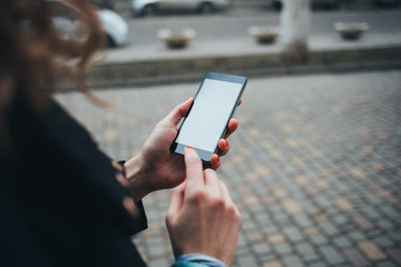 Closeup female hands with red manicure typing on smart phone