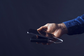 man holds phone and external battery