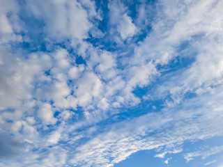 Fluffy white clouds in perspective in the blue sky.