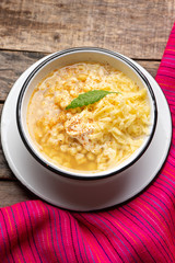 Mexican corn grain boiled also called esquites with cheese and mayonnaise on wooden background