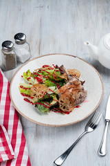 Warm fine gourmet salad with sous vide rabbit meat and lotus root chips