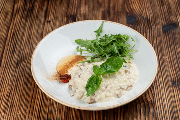 Classic italian creamy risotto with mushrooms and arugula