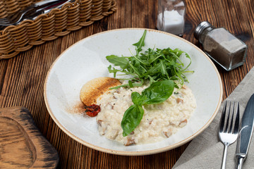 Classic italian creamy risotto with mushrooms and arugula