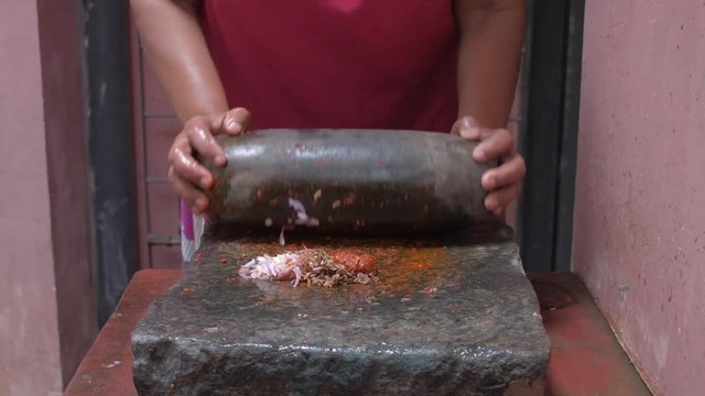 Traditional Sri Lankan way of grinding spices with the grinding stone. 
