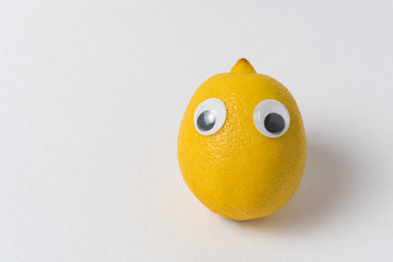 Fresh Lemon with eyes on white background. Food with Funny Face.