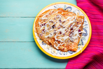 Mexican red enchiladas with melted cheese on turquoise background