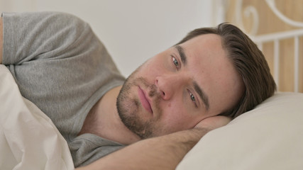 Portrait of Young Man Thinking in Bed