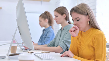 Young Woman Working on Desktop and Coughing