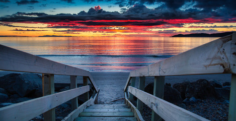 The  wooden stairs leading to the stunning sunset cloudscape over the horizon as night falls