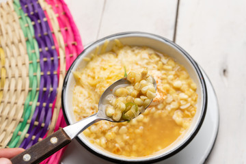 Mexican corn grain boiled also called esquites with cheese and mayonnaise on white background