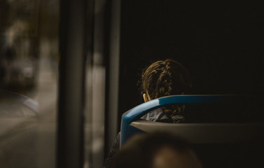 Chica sentada en un autobus, reflejo de la ventana, moody, intenso