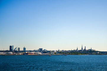 Fototapeta premium View of Old town Tallinn from cruise ship. The calm expanse of the Baltic Sea. In the distance, modern buildings the ancient cathedrals and tower on the coast. Estonia