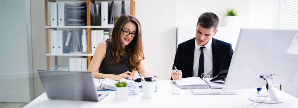 Two Business People Doing Finance Work - Powered by Adobe