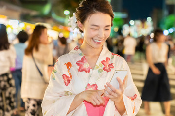 浴衣を着た女性　お祭り　スマホ