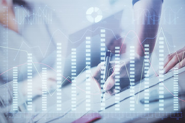 A woman hands writing information about stock market in notepad. Forex chart holograms in front. Concept of research. Double exposure