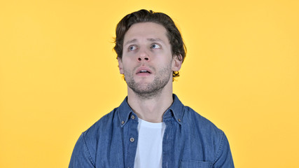 Worried Young Man Feeling Shocked on Yellow Background