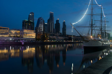 An old ship in a harbor with some building