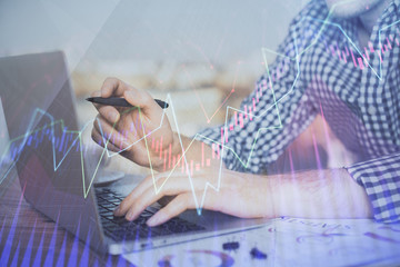 Double exposure of forex graph with man working on computer on background. Concept of market...