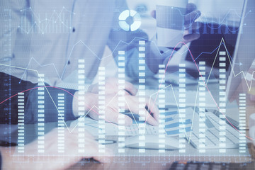 Multi exposure of chart with man typing on computer in office on background. Concept of hard work.
