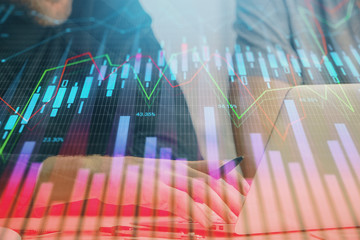 Forex graph with businessman typing on computer in office on background. Concept of analysis. Double exposure.