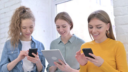 Cheerful Team Using Smartphone and Tablet