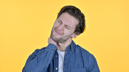 Exhausted Young Man with Neck Pain on Yellow Background
