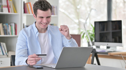 Successful Online Shopping by Young Man on Laptop