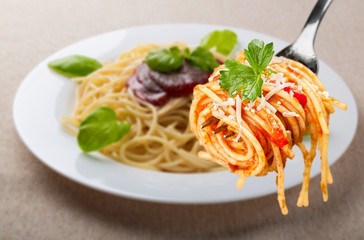 Metal fork with delicious spaghetti and sauce