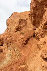 Rocks in canyon of dry river bed. Drought due to climate change. Soil erosion of hills. Red sand in mountains