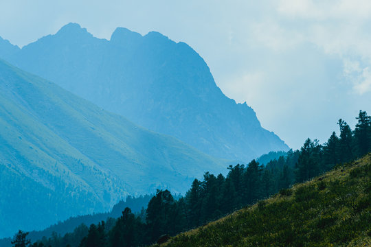 high cliffs in blue haze, silhouette of mountain range in fog, meditation and relaxation in nature