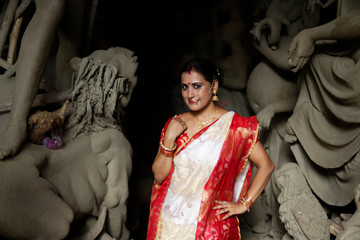 Portrait of an young and beautiful Indian Bengali brunette woman in red and white traditional...